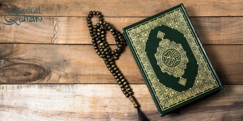 A Quran resting on a wooden table, showcasing its intricate cover and the natural texture of the wood beneath it.