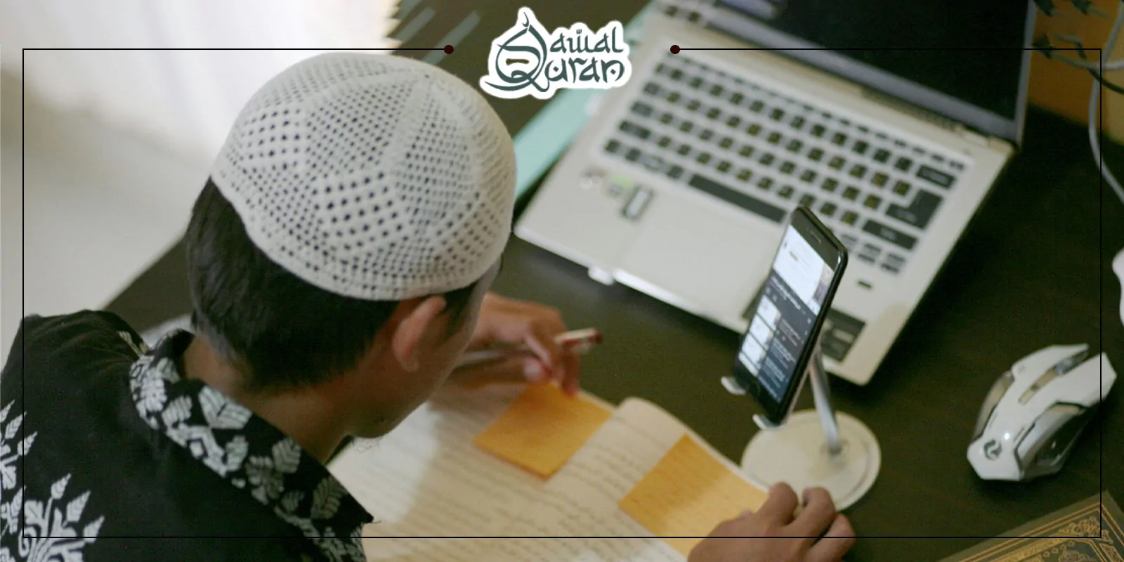 A man wearing a white hat is focused on writing on his laptop at a desk.