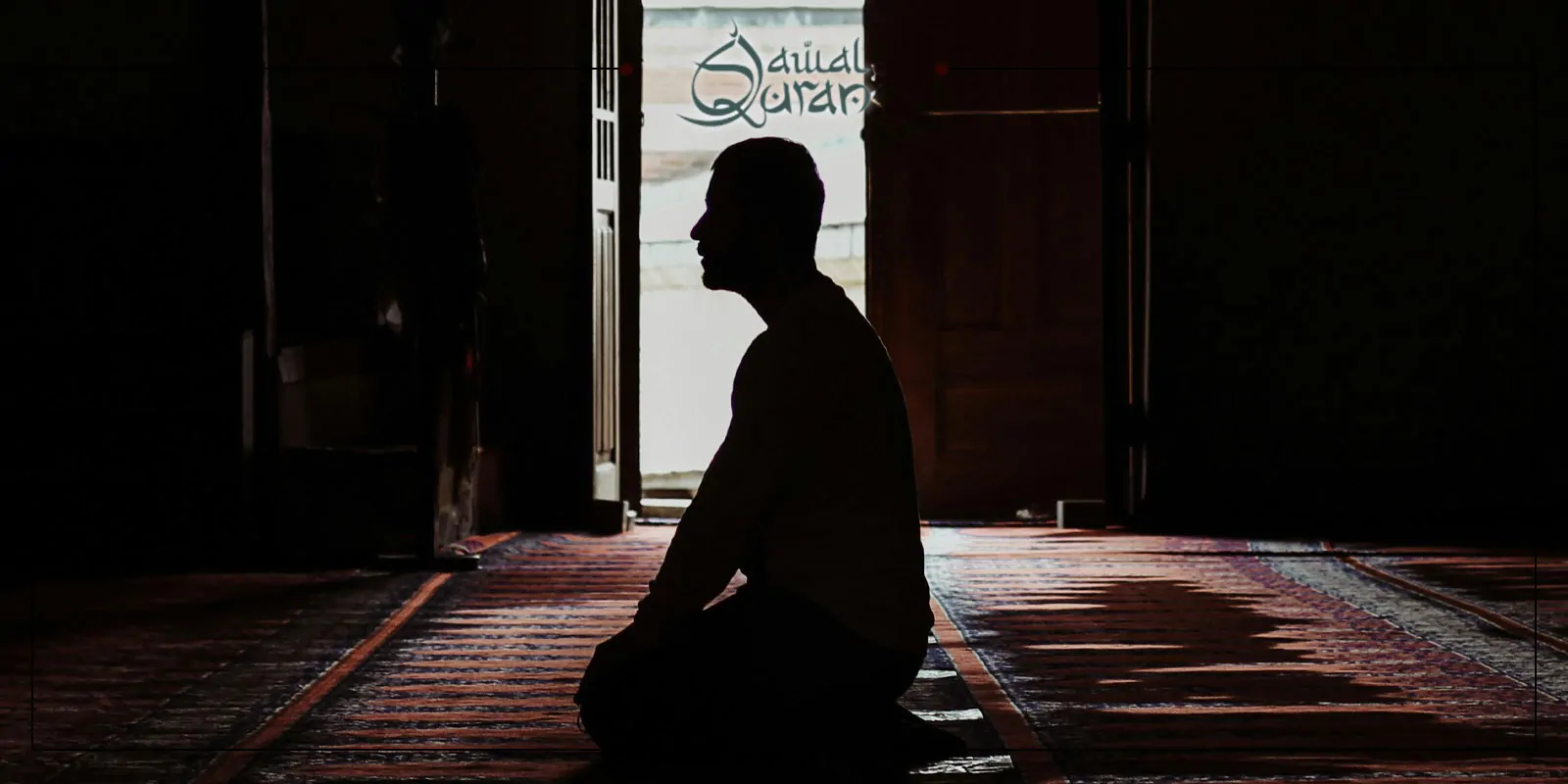 A man seated in a room, with an open door in the background, indicating a connection to the outside.